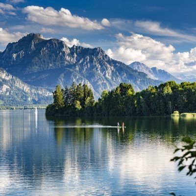 Germany, Allgäu, Forggensee lake, panorama with 2 standing up paddlers