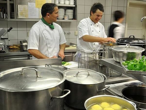 Köche mit Töpfen in der Küche vom Storchen