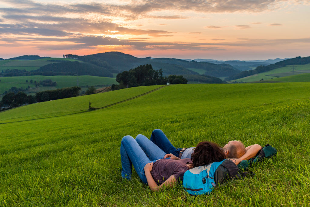 Wanderer genießen den Sonnenuntergang über dem Hennetal bei Oberhenneborn - so idyllisch sind Wanderausflüge im Sauerland