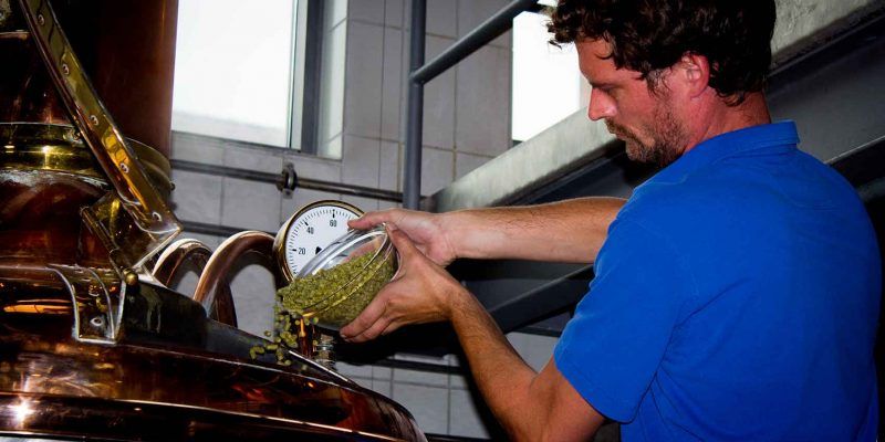 Der Braumeister im Bayerischen Brauereimuseum in Kulmbach gibt Hopfen in den Sudkessel.