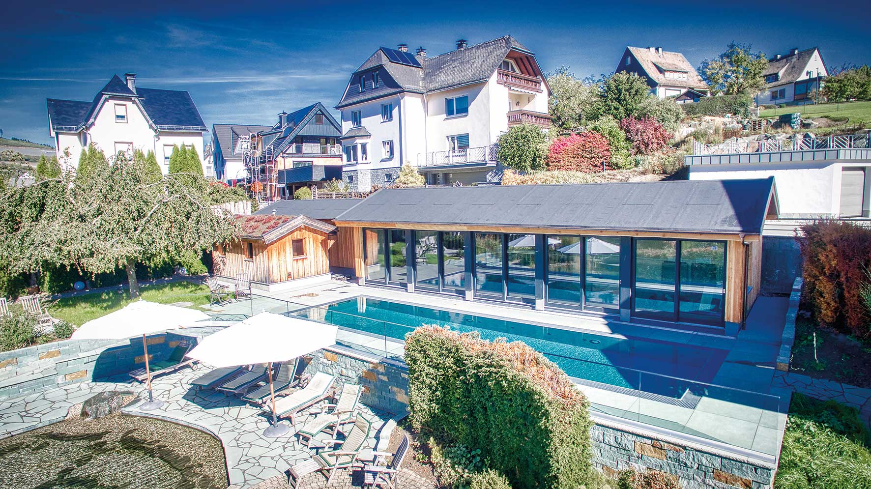 Foto vom beheizten Pool im Flair Hotel Nieder im Sauerland inklusive der Ruheliegen