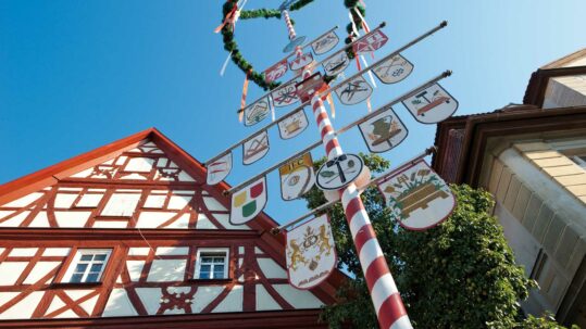 Foto von einem Fachwerkhaus und dem Handwerksbaum auf dem Kornmarkt in Bad Windsheim