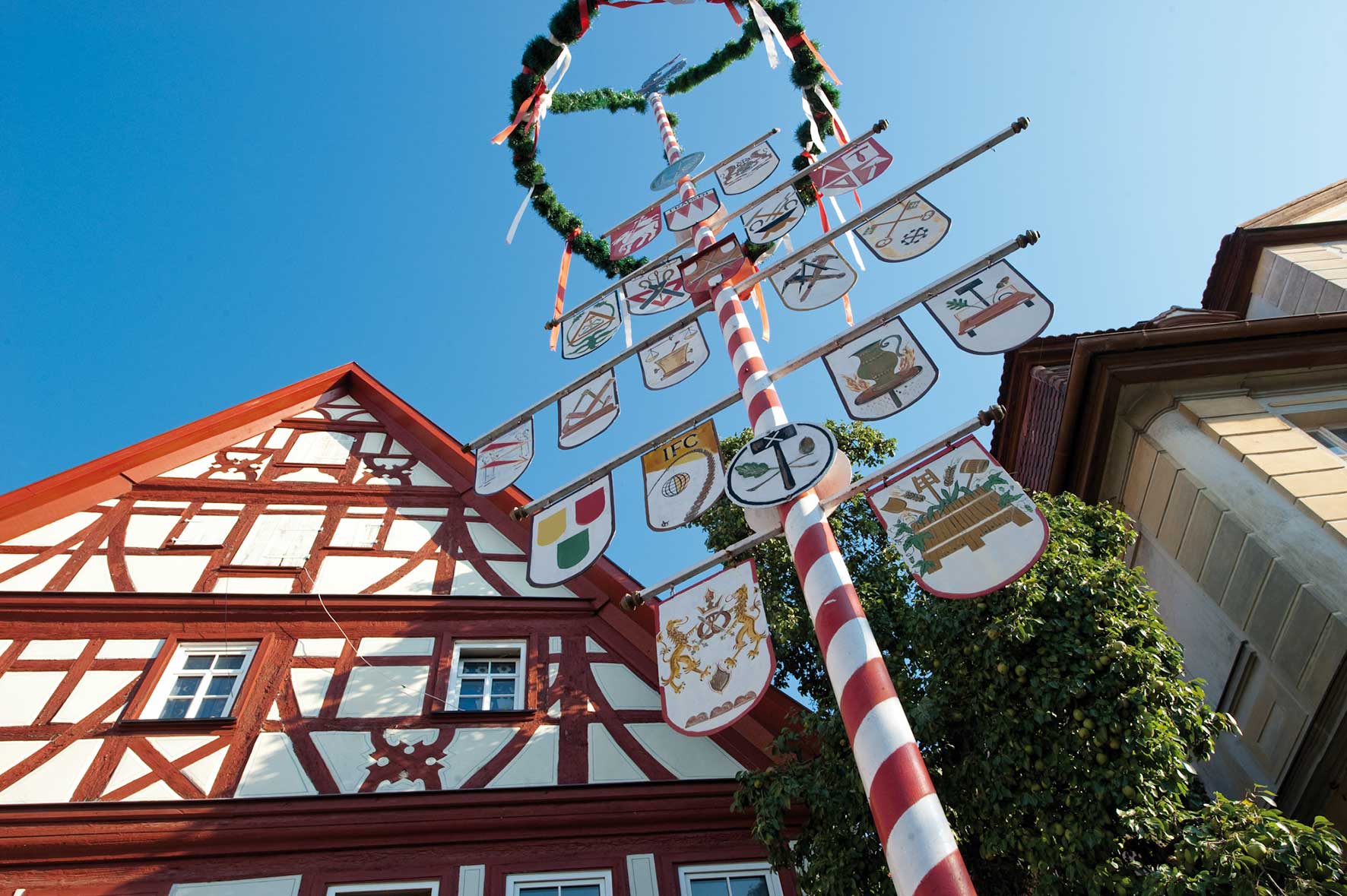Foto von einem Fachwerkhaus und dem Handwerksbaum auf dem Kornmarkt in Bad Windsheim