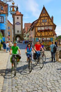 Foto von vier Radfahrern, die durch Rothenburg fahren