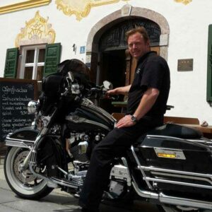 Foto von Hotelier Wolfgang Pallauf auf dem Motorrad. Das Flair Hotel Zur Post in Samerberg ist idealer Ausgangspunkt für einen Motorradurlaub in den Bergen