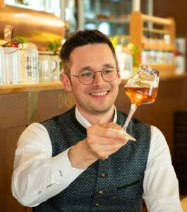 Foto von Brauer und Biersommelier Michael Sperber, der mit Genuss sein Bier im Glas betrachtet.