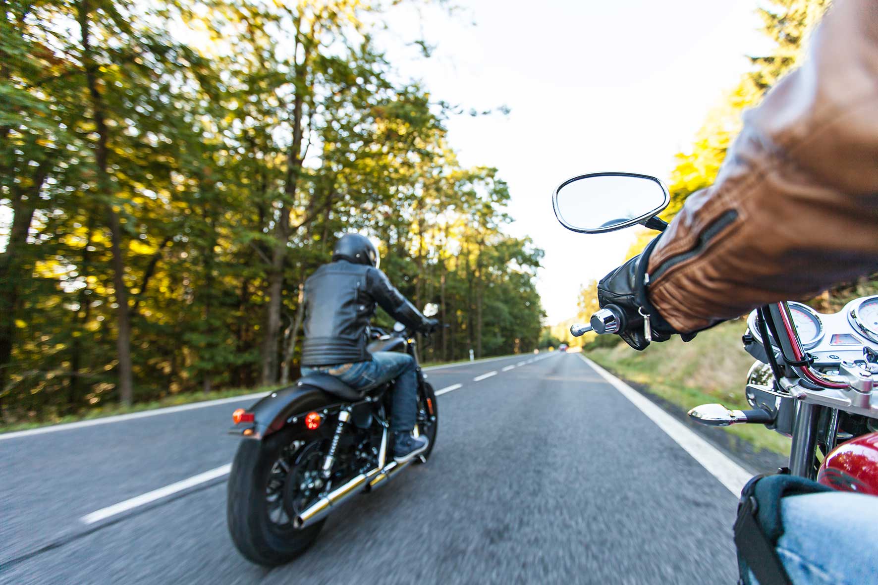 Foto von zwei fahrenden Motorrädern auf der Straße, mit dem Rücken zur Kamera