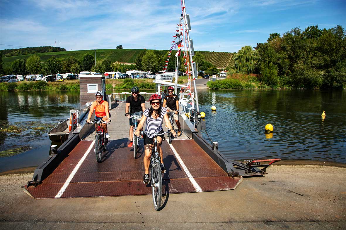 Radfahrer verlassen eine Fähre am MainRadweg