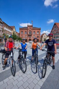 Foto von vier Radfahrern, die in Tauberbischofsheim für die Kamera posieren.