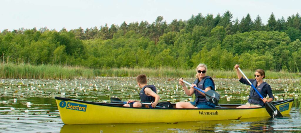 Kanufahrer während der Seerosenblüte im Seerosenparadies in der Mecklenburgischen Seenplatte bei Mirow