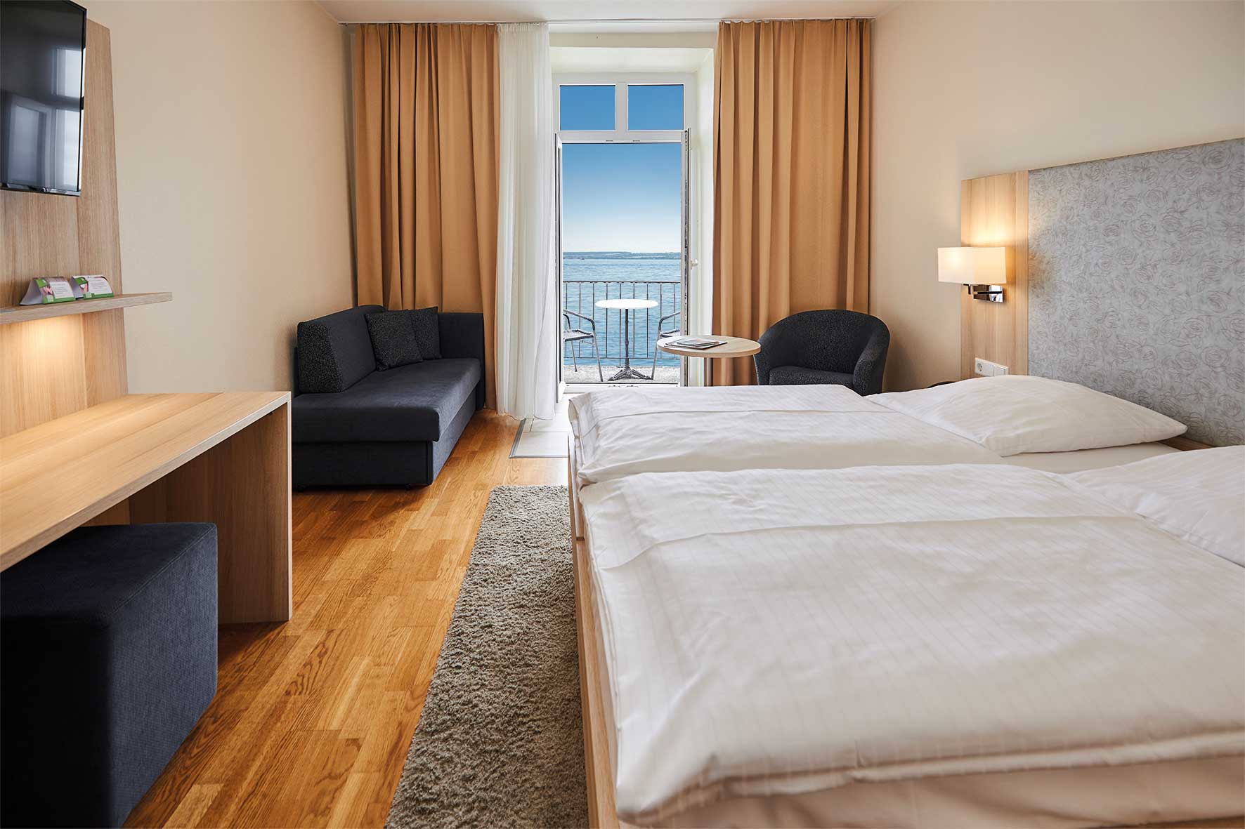 Foto von einem Zimmer im Flair Hotel Zum Schiff am Bodensee. Die Balkontür ist geöffnet und man hat einen schönen Blick auf den See.